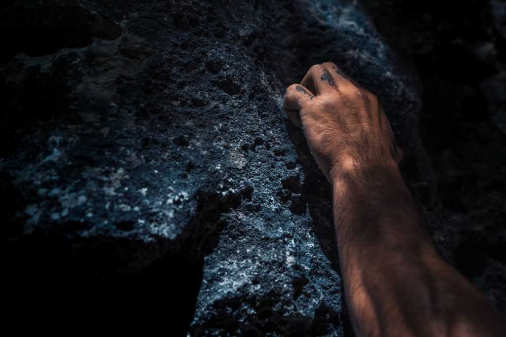 Mano con magnesite su roccia scura