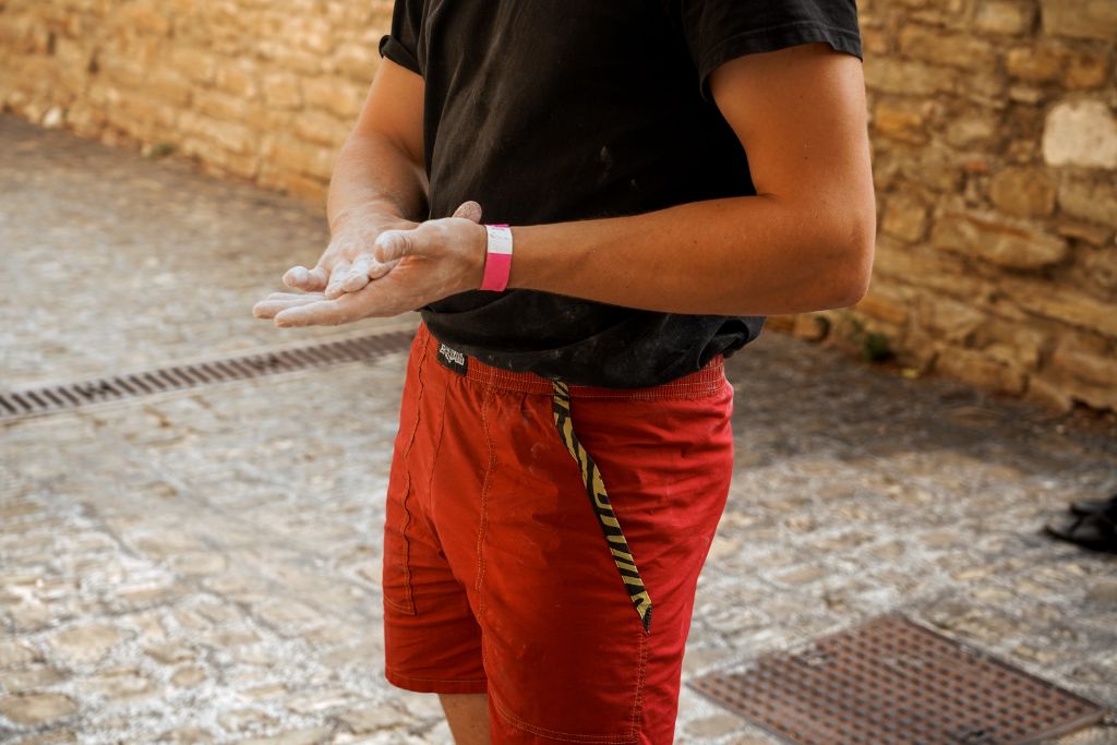 Mani con magnesite e pantaloncini rossi in strada