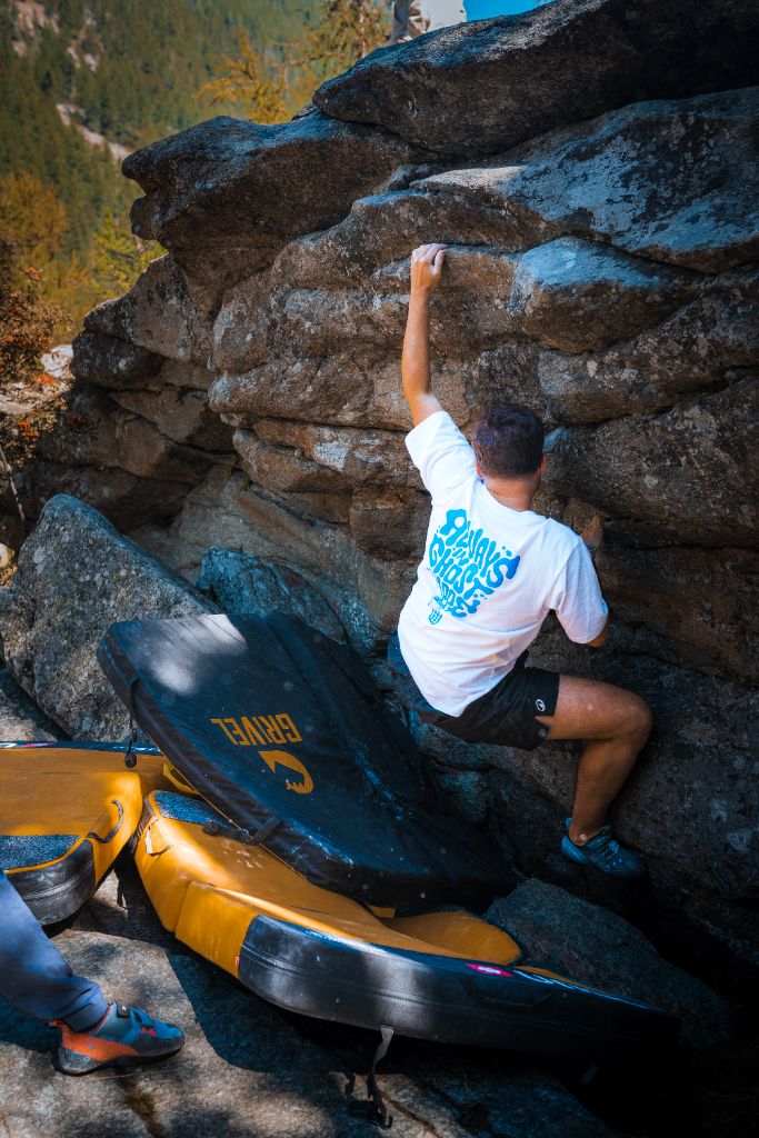 Boulder sui massi con la maglia Lazy Ghost e crash pad